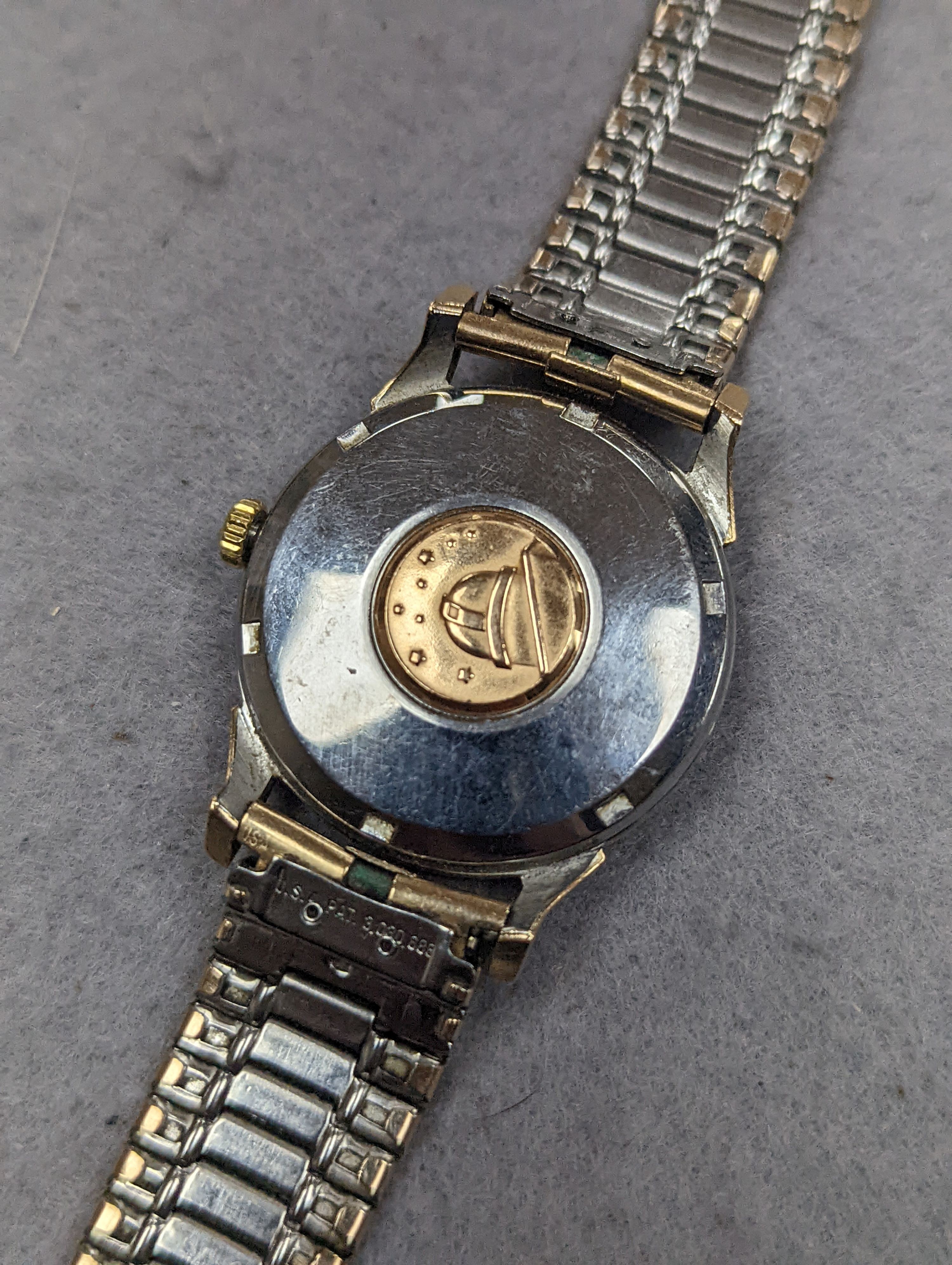 A gentleman's steel and gold plated Omega Automatic Constellation black dial wrist watch, on associated bracelet, case diameter 34mm (winding crown a.f.).